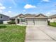 Charming single-story home featuring a three-car garage and inviting front lawn at 1936 Bell Creek Loop, Fruitland Park, FL 34731