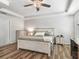 Serene main bedroom featuring tray ceilings, ceiling fan, and wood-look flooring at 1936 Bell Creek Loop, Fruitland Park, FL 34731