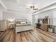 Comfortable main bedroom featuring a tray ceiling, ceiling fan, and wood-look flooring at 1936 Bell Creek Loop, Fruitland Park, FL 34731