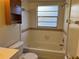 Bathroom with white tile, vanity, tub, and window offers a clean and functional space at 2408 Fabry Cir, Orlando, FL 32817