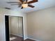 This bedroom features hardwood floors, a ceiling fan, and a mirrored closet at 2408 Fabry Cir, Orlando, FL 32817