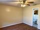 Neutral bedroom with hardwood floors, ceiling fan, and a view into the attached bathroom at 2408 Fabry Cir, Orlando, FL 32817