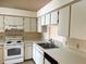 Bright kitchen features white cabinets, countertops, and appliances for a clean, modern look at 2408 Fabry Cir, Orlando, FL 32817