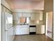 Functional kitchen features white appliances, tile flooring, ample counter space and cabinetry for a practical cooking space at 2408 Fabry Cir, Orlando, FL 32817