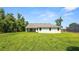 Lush backyard view of home with a covered patio and freshly cut lawn, perfect for outdoor enjoyment at 2561 Rogers Rd, Lakeland, FL 33812