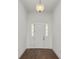 Bright foyer featuring an elegant light fixture, classic trim and gleaming hardwood floors at 2561 Rogers Rd, Lakeland, FL 33812