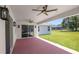 Covered patio with brick flooring, ceiling fans, and sliding glass doors lead to backyard and house at 2561 Rogers Rd, Lakeland, FL 33812