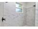 Modern walk-in shower with white marble-style tile and black fixtures at 2561 Rogers Rd, Lakeland, FL 33812