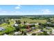 Aerial view of the property and neighborhood, featuring the home, a pond, and surrounding greenery at 34 Misty Meadow Ln, Mulberry, FL 33860