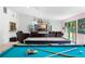 Well-equipped entertainment area with pool table, air hockey table, and comfortable seating with a view of a large TV at 34 Misty Meadow Ln, Mulberry, FL 33860