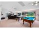 Spacious game room includes an air hockey and pool table, and access to an entertainment center and backyard at 34 Misty Meadow Ln, Mulberry, FL 33860
