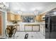 Charming kitchen with wood cabinets, updated appliances, and decorative light fixtures at 34 Misty Meadow Ln, Mulberry, FL 33860