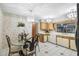 Vintage-style kitchen with chandeliers, a glass-top table with ornate chairs, tile flooring, and wood cabinets at 34 Misty Meadow Ln, Mulberry, FL 33860