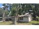 View of the home's exterior featuring a brick chimney and lots of surrounding trees at 4202 Sunny View Dr, Lakeland, FL 33813