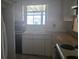 A view of the kitchen area with white appliances and a window above the sink at 4202 Sunny View Dr, Lakeland, FL 33813