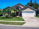 Inviting single-Gathering home showcasing a well-manicured lawn and driveway leading to an attached two-car garage at 4613 Eaglet Ln, Kissimmee, FL 34746