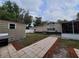 Well-maintained backyard with a paved walkway leading to a shed and the main house at 4814 Myrtle View N Dr, Mulberry, FL 33860