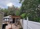 Beautiful backyard featuring a hammock, custom-built patio, white fence and lush greenery offering privacy and charm at 4814 Myrtle View N Dr, Mulberry, FL 33860