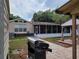Backyard view with patio, screened enclosure, grill, and landscaping, perfect for outdoor gatherings and relaxation at 4814 Myrtle View N Dr, Mulberry, FL 33860