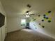 Bedroom with carpet, ceiling fan, rocking chair, and hexagon wall pattern at 4814 Myrtle View N Dr, Mulberry, FL 33860