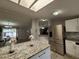 Bright kitchen island featuring granite countertops and stainless steel refrigerator at 4814 Myrtle View N Dr, Mulberry, FL 33860