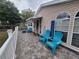 Relaxing covered porch with blue Adirondack chairs, tile flooring, and white railings at 4814 Myrtle View N Dr, Mulberry, FL 33860