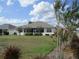 Expansive backyard with a screened-in lanai, complemented by mature trees and well-maintained landscaping at 7157 Hazeltine Cir, Lakeland, FL 33810
