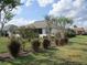 View of the well-kept backyard, featuring neatly trimmed shrubs, small trees, and a lush green lawn at 7157 Hazeltine Cir, Lakeland, FL 33810