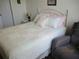 Bedroom with white-frame bed, chair, and lamp on nightstand at 7157 Hazeltine Cir, Lakeland, FL 33810