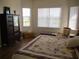 Inviting bedroom with a floral-patterned quilt, dark wood furniture, and bright natural light at 7157 Hazeltine Cir, Lakeland, FL 33810