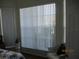 Bright bedroom window with a chair underneath and a lamp stand at 7157 Hazeltine Cir, Lakeland, FL 33810