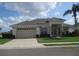 Well-maintained single story home with a two-car garage, neatly trimmed landscaping, and lush green lawn at 7157 Hazeltine Cir, Lakeland, FL 33810