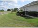 Manicured lawn, featuring neatly trimmed shrubs, with small trees and pink flowers lining the side of the home at 7157 Hazeltine Cir, Lakeland, FL 33810