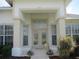 Close-up view of the welcoming front entrance with glass double doors and decorative potted flowers at 7157 Hazeltine Cir, Lakeland, FL 33810