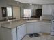 Well-lit kitchen featuring neutral countertops, a white dishwasher, and white appliances at 7157 Hazeltine Cir, Lakeland, FL 33810