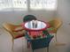 Outdoor patio setting with four colorful wicker chairs surrounding a glass table at 7157 Hazeltine Cir, Lakeland, FL 33810
