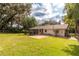 Expansive backyard features a brick patio, lush lawn, mature trees, and a charming single-story home at 727 Se 12Th St, Ocala, FL 34471