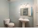 Charming bathroom with a pedestal sink, white toilet, and light blue walls and trim at 727 Se 12Th St, Ocala, FL 34471