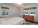 Bright bedroom featuring hardwood floors, two windows, and a dresser for storage at 727 Se 12Th St, Ocala, FL 34471