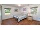 Bright bedroom with hardwood floors, two windows providing natural light, and a decorative painting at 727 Se 12Th St, Ocala, FL 34471