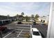 Exterior view of parking lot, palm trees, community pool, and buildings under a blue, cloudy sky at 1000 S Semoran Blvd # 306, Winter Park, FL 32792