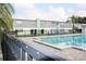 Community pool featuring a black metal fence and lounging chairs at 1000 S Semoran Blvd # 408, Winter Park, FL 32792
