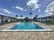 A community swimming pool is framed by lush palm trees and a blue, partly cloudy sky at 1000 S Semoran Blvd # 408, Winter Park, FL 32792