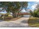 Attractive one-story home showcasing mature trees, a long driveway, and a well-maintained lawn at 10441 Sw 54Th Ct, Ocala, FL 34476