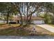 Charming one-story home with mature trees, a well-manicured lawn, and a two-car garage at 10441 Sw 54Th Ct, Ocala, FL 34476