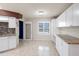 Bright kitchen featuring white cabinets, granite countertops, and stainless steel appliances with stylish tile flooring at 10441 Sw 54Th Ct, Ocala, FL 34476
