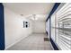Bright living room featuring tile floors, a modern ceiling fan, and white walls contrasted by a deep blue accent wall at 10441 Sw 54Th Ct, Ocala, FL 34476