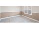 A neutral room featuring tile flooring, wainscoting, and a window with plantation shutters at 10441 Sw 54Th Ct, Ocala, FL 34476
