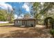 Backyard shed with matching colors to the main house, surrounded by mature landscaping at 10441 Sw 54Th Ct, Ocala, FL 34476