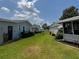 Backyard featuring large green lawn, exterior features, and surrounding residential structures at 106 Pyracantha Ln, Leesburg, FL 34748